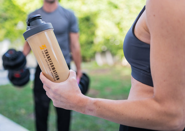 Woman holding Transformation Protein drink